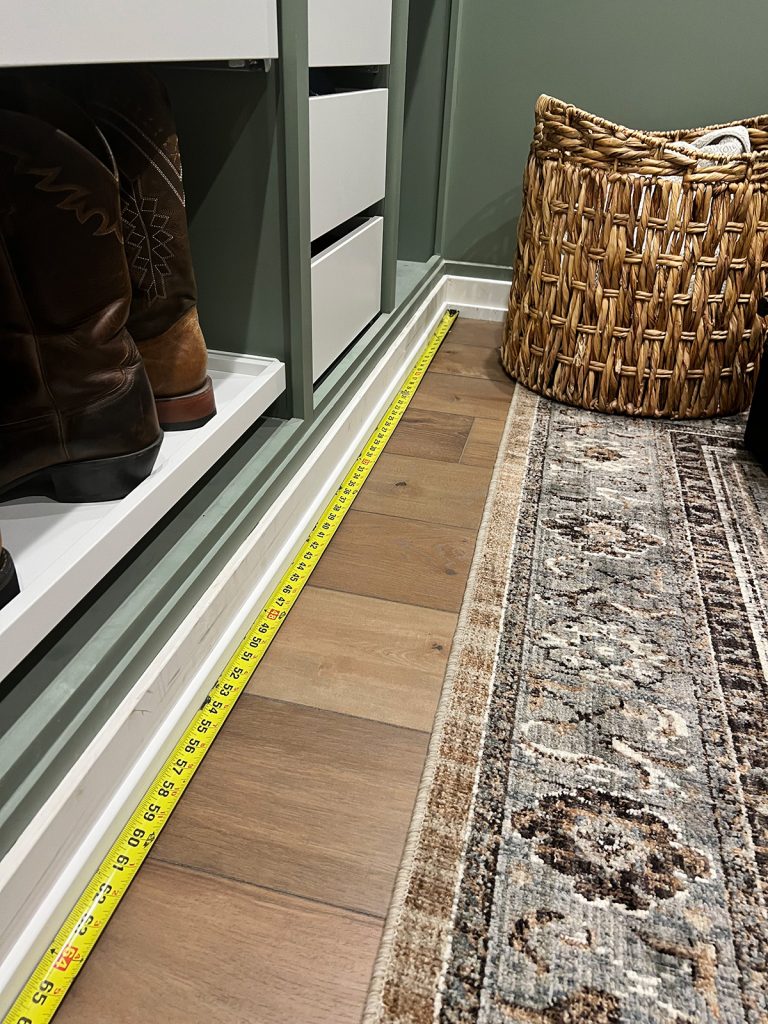Measuring tape against the baseboards showing the direction I work around a room; picture is of our closet with an Ikea pax organizing system in place.