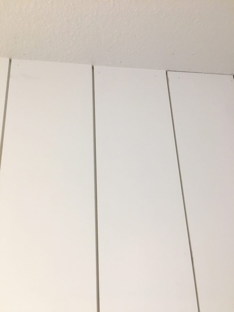 comparison of vertical shiplap boards with caulking along the ceiling edge and without