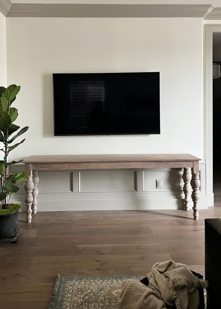 The console table set against the wall beneath our bedroom tv creates a more beautiful focal point in front of our wainscoting wall panel then just the black hole the tv created 