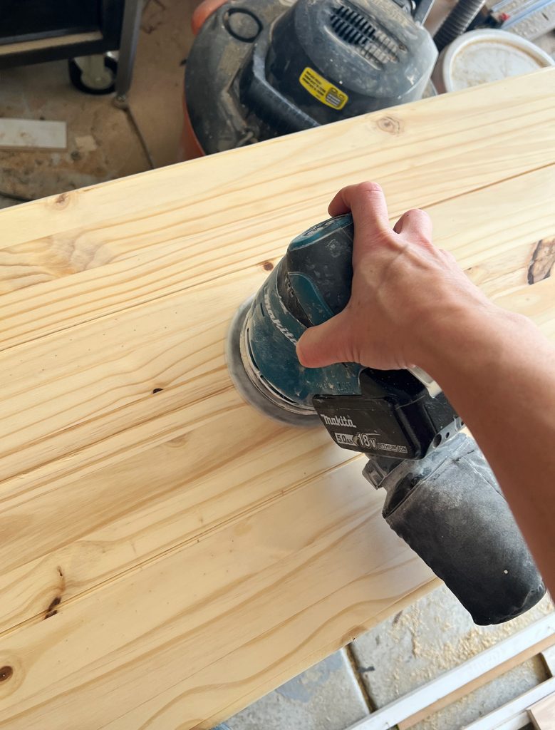 an electric sander is being used on the table top.
